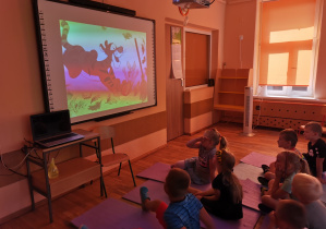 Dzieci oglądają bajkę na dużym ekranie