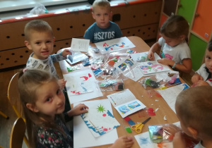 Dzieci wykonują piaskowe malowanki.