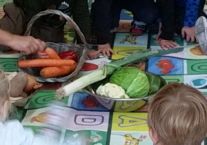 Chłopcy oglądają naturalne okazy warzyw.