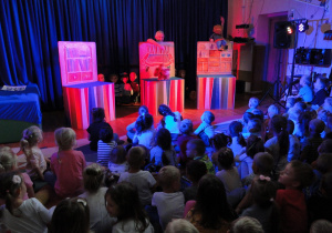 Dzieci patrzące na przedstawienie teatralne – marionetki.