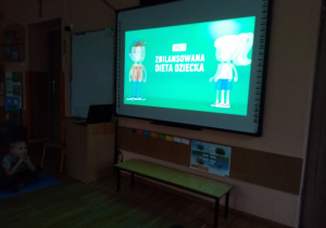 Przedszkolaki oglądają prezentację multimedialną pt. „Zbilansowana dieta dziecka”.