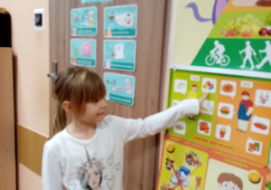 Dziewczynka wskazuje na planszy zdrowe produkty.