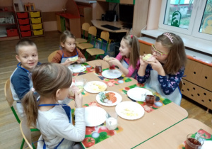 Dzieci degustują przygotowane przez siebie kanapki.