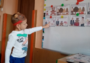 Chłopiec wskazuje na tablicy ilustrację przedstawiającą historię misia.