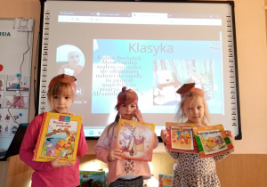 Dziewczynki pokazują książki z Kubusiem Puchatkiem.