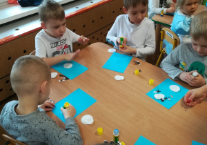 Dzieci wykonują Olafa z Krainy Lody z użyciem różnych materiałów plastycznych