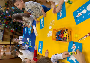 Dzieci z grupy 4 integracyjnej wykonują Olafa z Krainy Lody z użyciem różnych materiałów plastycznych