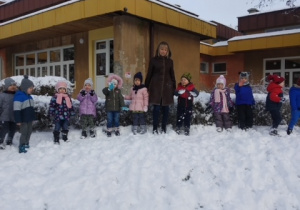 Dzieci z gr 2 z panią Beatą pozują do pamiątkowego zdjęcia na górce śniegowej
