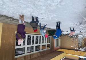 Dzieci bawią się śniegiem w ogrodzie przedszkolnym