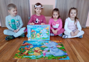 Dzieci prezentują ułożone puzzle.