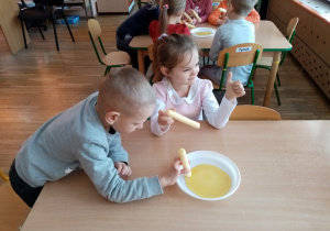 Dzieci degustują ulubiony przysmak Kubusia- miód.