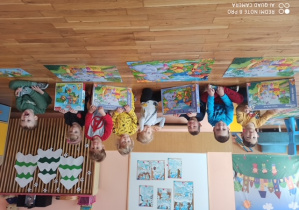 Dzieci prezentują ułożenie puzzle przedstawiające ilustracje Kubusia Puchatka i jego przyjaciół