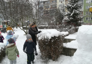 Dzieci i panie bawiące się śniegiem