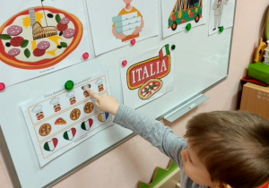 Chłopiec z gr 3 rozwiązuje łamigłówki związane ze świętem pizzy