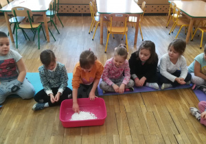Dzieci sprawdzają konsystencje białego proszku w misce