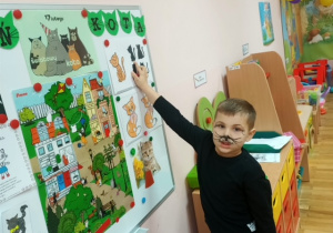 Chłopiec z gr 3 wskazuje na tablicy rożnego rodzaju koty