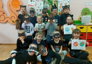 Dzieci z gr 3 pozują do pamiątkowego zdjęcia w maskach „KOT”