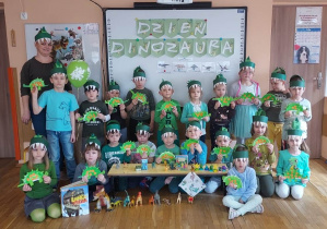 Pamiątkowe zdjęcie - dzieci z grupy 5 trzymają swoje papierowe dinozaury