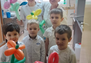 Chłopcy obdarowują balonowymi kwiatami panie z kuchni