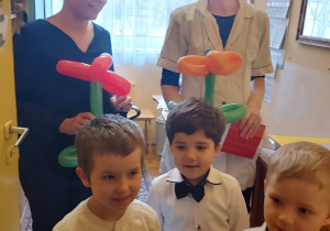 Chłopcy obdarowują balonowymi kwiatami panią intendentkę i kucharkę