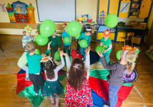 Dzieci bawią się balonami podrzucając do góry