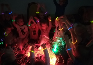 Dzieci bawiące się kolorowymi światłami, świetlnymi bransoletkami.
