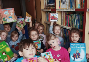 Dzieci pozują do pamiątkowego zdjęcia z wybranymi książkami