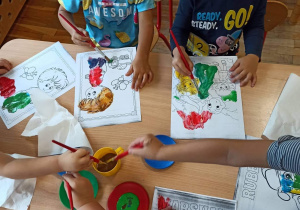 Dzieci kolorują farbami bajkowe zwierzątka