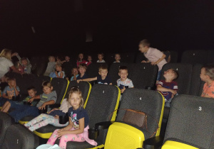 Dzieci siedzą na fotelach kinowych oczekując na bajkę