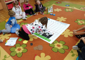 Dzieci układają na dywanie zakodowany obrazek