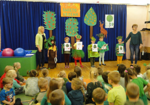 Dzieci rozwiązują zagadki o znanych drzewach.
