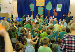 Dzieci wykonują taniec z kolorowymi liściami.