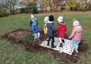 Dzieci spacerują w ogrodzie po ścieżce sensorycznej