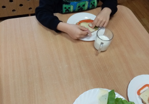 Chłopiec przygotowuje kanapkę ze zdrowych produktów.