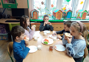 Dzieci jedzą przygotowane przez siebie zdrowe śniadanie.