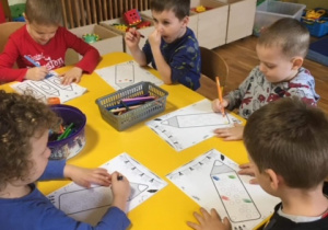Dzieci kolorują kolorowanki z kredkami
