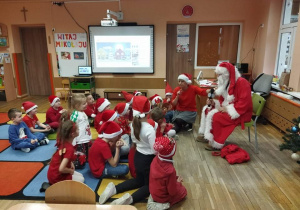 Dzieci rozmawiają z Mikołajem, zadają pytania.