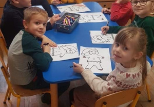 Dzieci z gr 4 integracyjnej kolorują piernikowego ludzika