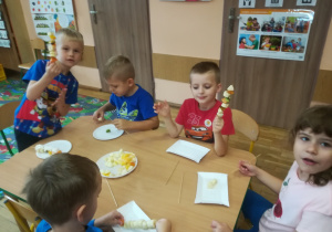Dzieci pokazują swoje owocowe szaszłyki.