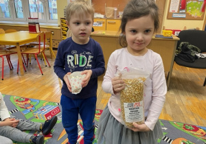 Dzieci prezentują składniki potrzebne do wybrukowania popcornu