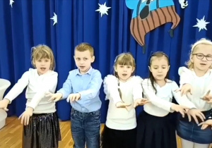 Dzieci śpiewają i naśladują piosenkę ruchem