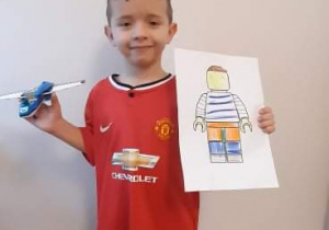 Chłopiec prezentuje samolot z klocków lego oraz rysunek lego-ludzika.
