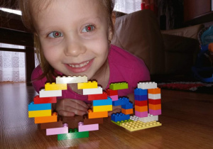 Dziewczynka pokazuje zbudowane przez siebie litery.