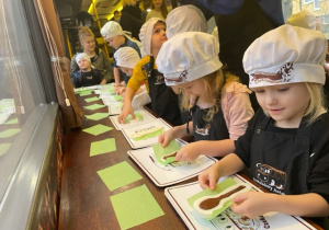Dzieci studzą czekoladę w foremkach