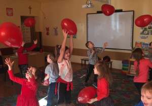 Dzieci wspólnie bawią się balonikami walentynkowymi