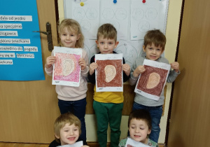 Dzieci pokazują swoje pokolorowane obrazki