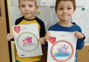 Dzieci pokazują pokolorowane przez siebie odznaki prawdziwych Super - Czyściochów.
