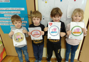 Dzieci pokazują pokolorowane przez siebie odznaki prawdziwych Super - Czyściochów