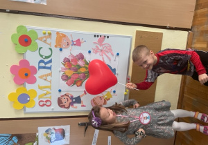 Wiktor ofiarowuje Zosi serduszko balonik