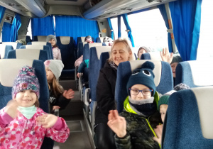 Zadowolone przedszkolaki podczas jazdy busem do kina.